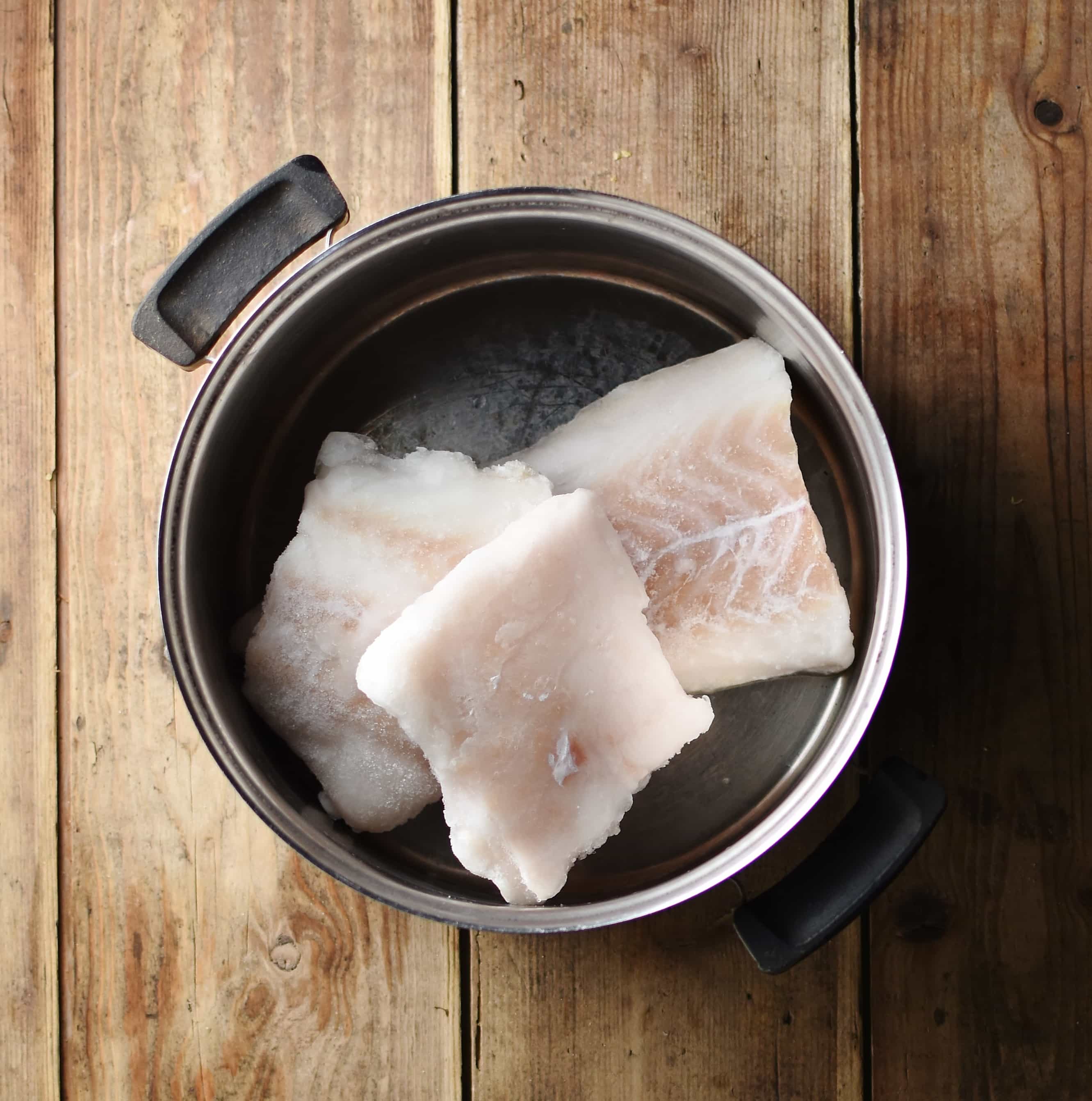 Fish fillets inside pot.