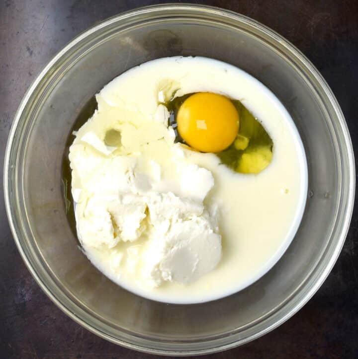 Ricotta, egg and milk in glass bowl.