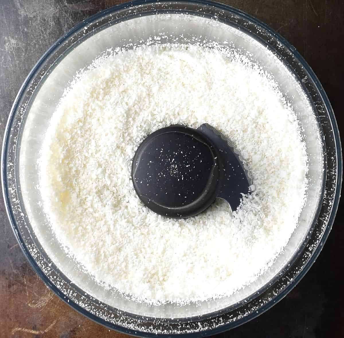 Desiccated coconut mixture in blender bowl.