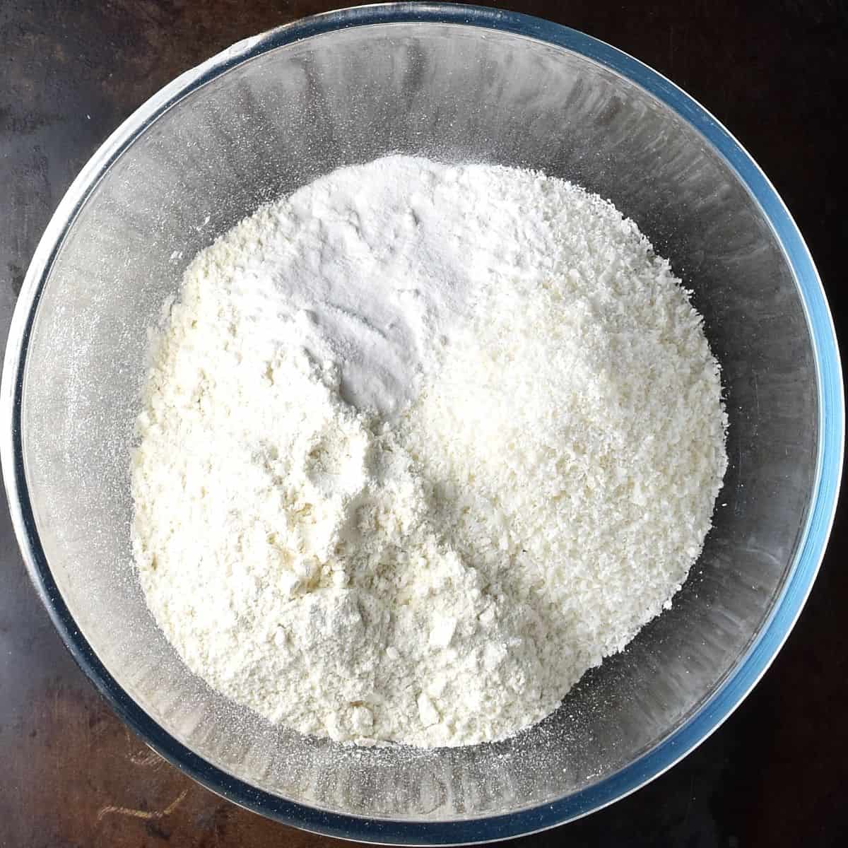 Flour and desiccated coconut in large glass bowl.