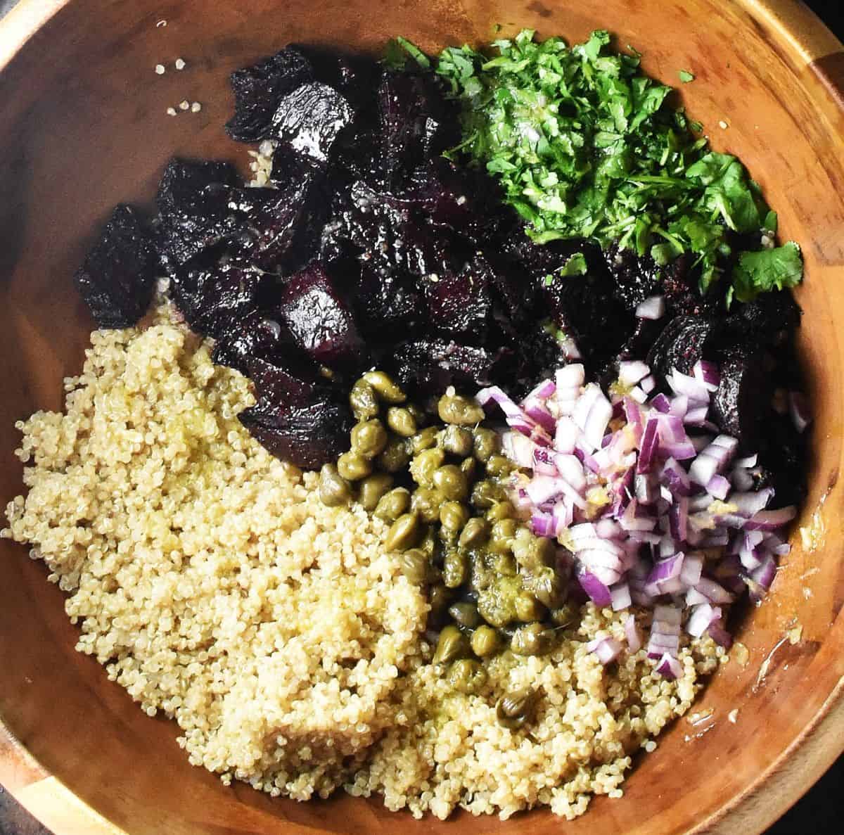 Salad ingredients assembled in large wooden bowl.