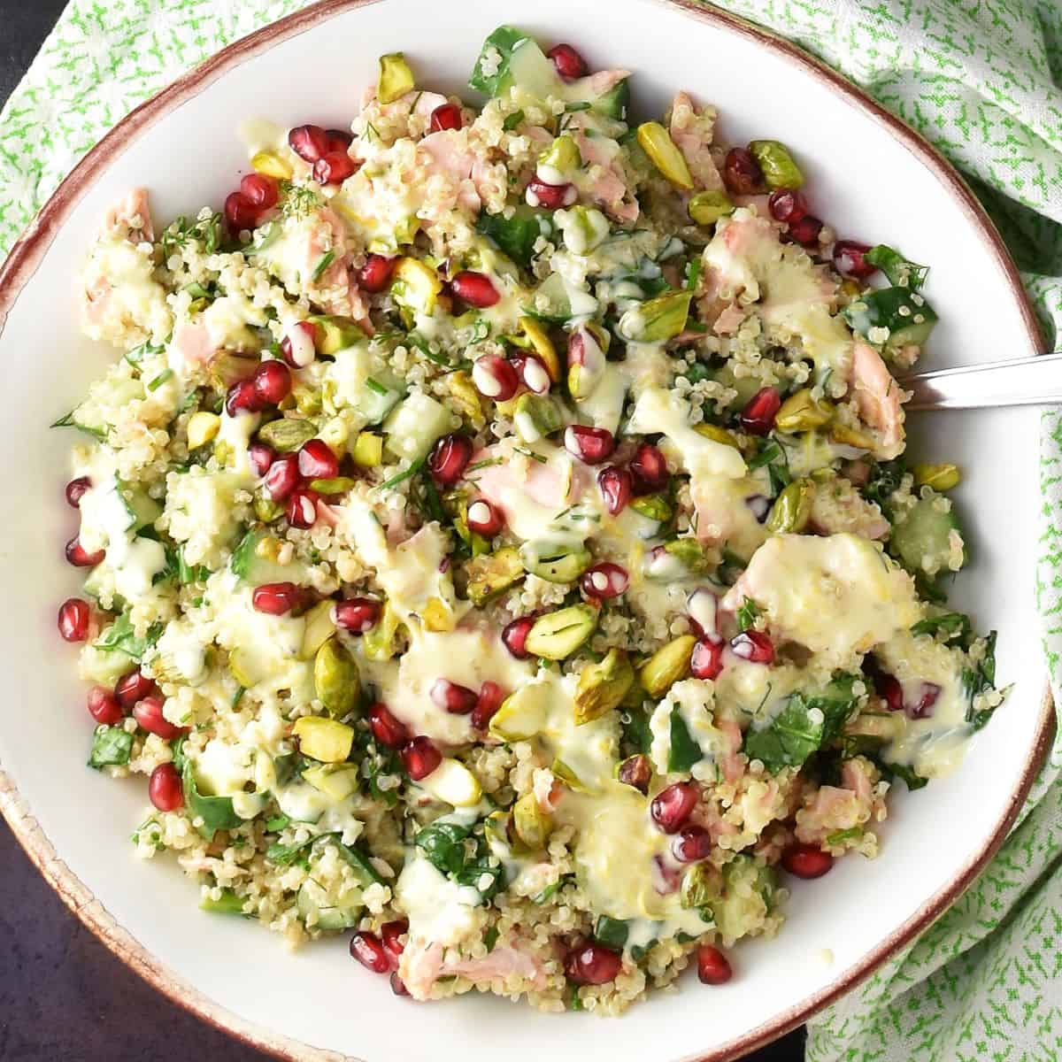 Top down view of quinoa salmon salad in white bowl.