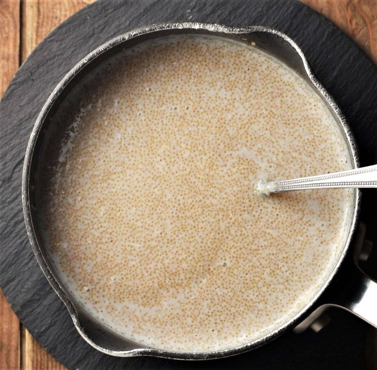 Cooked amaranth in saucepan with spoon.