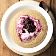 Amaranth porridge with fruit and yogurt in white bowl.