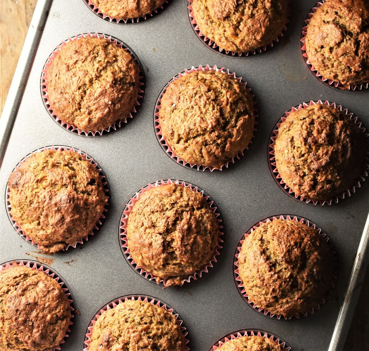 Top down view of 12 carrot muffins in pan.
