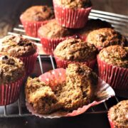 Side view of carrot date muffins in red liners on top of cooling rack.