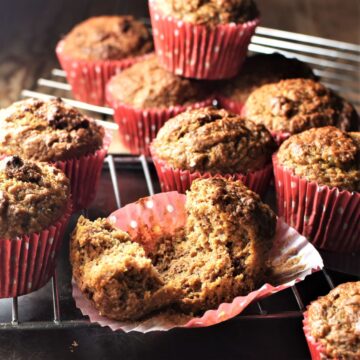 Side view of carrot date muffins in red liners on top of cooling rack.