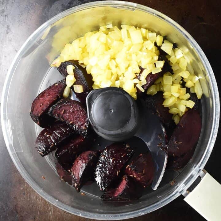 Roasted beets and fried chopped onion in food processor bowl.