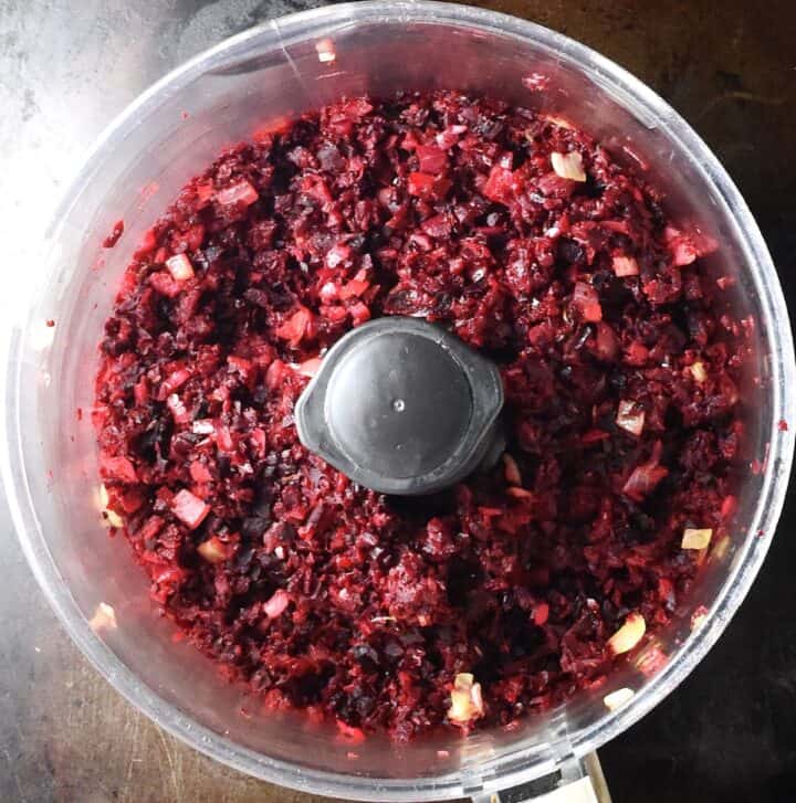 Coarse beetroot mixture in food processor bowl.