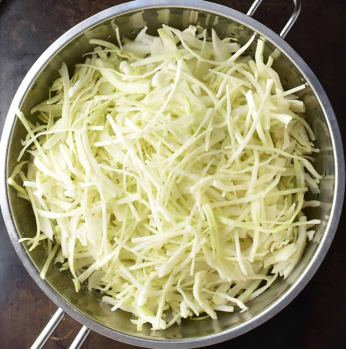 Top down view of shredded cabbage in strainer.