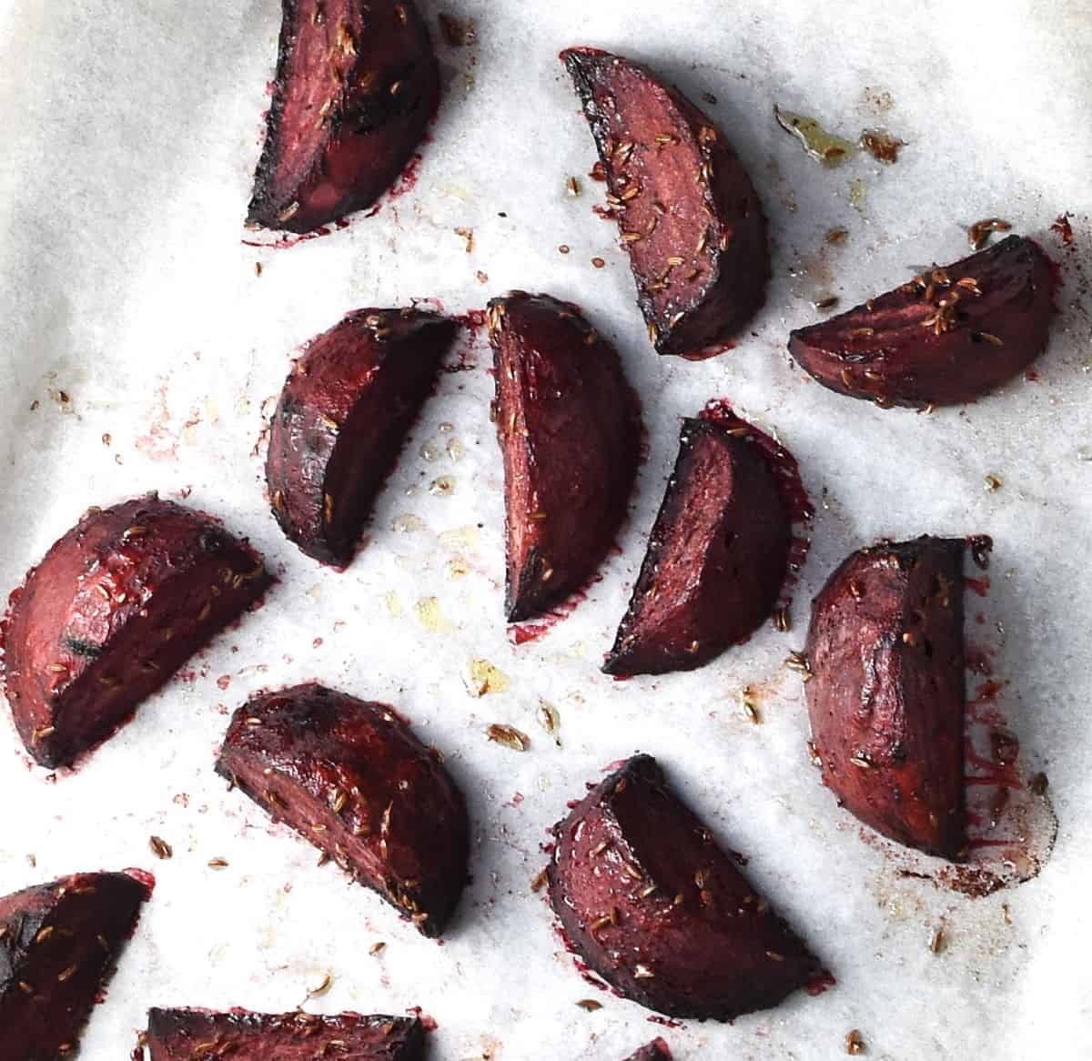 Roasted beet wedges on top of parchment.