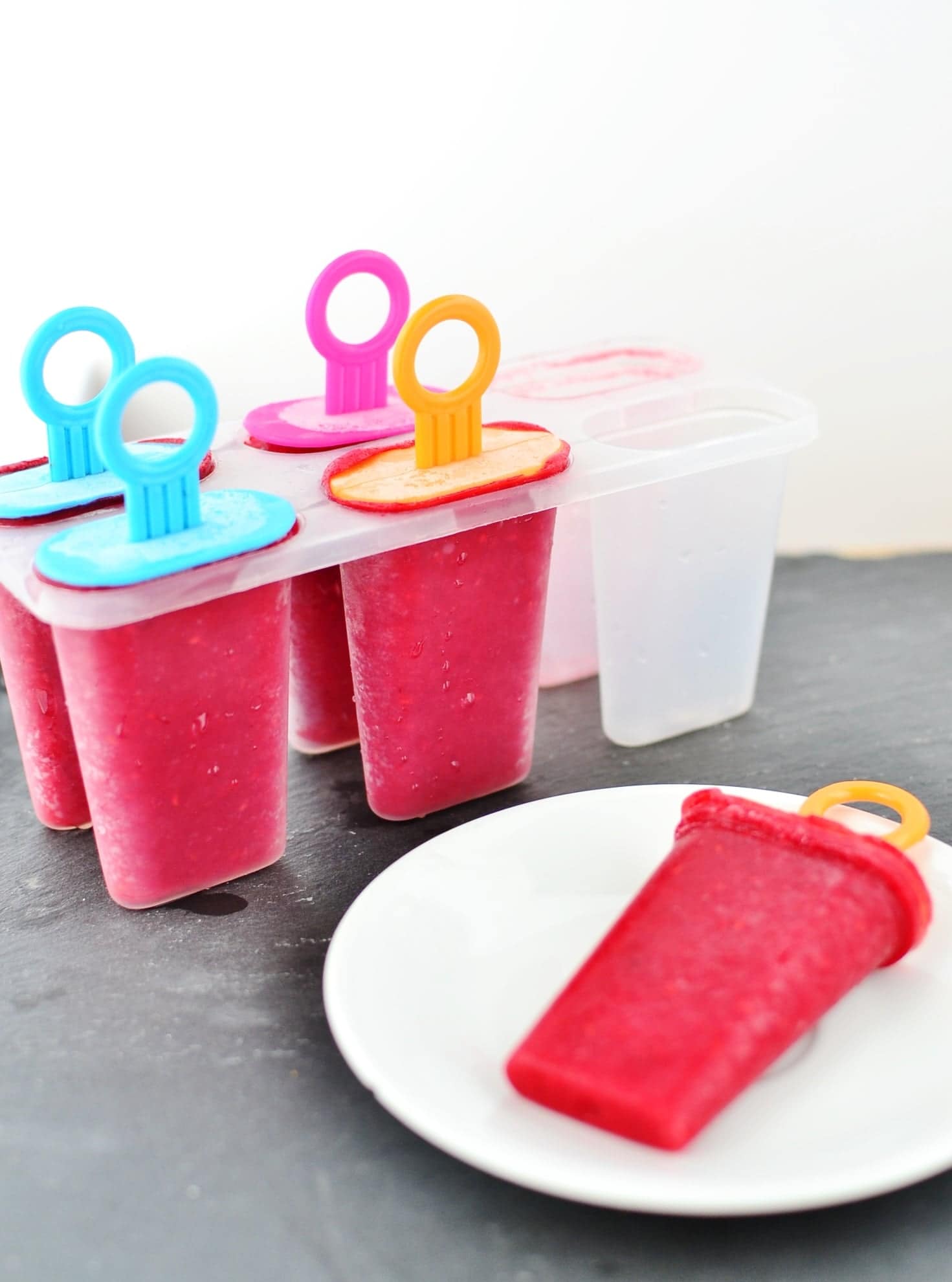 Rooibos raspberry ice pops on small white plate and in plastic mold.
