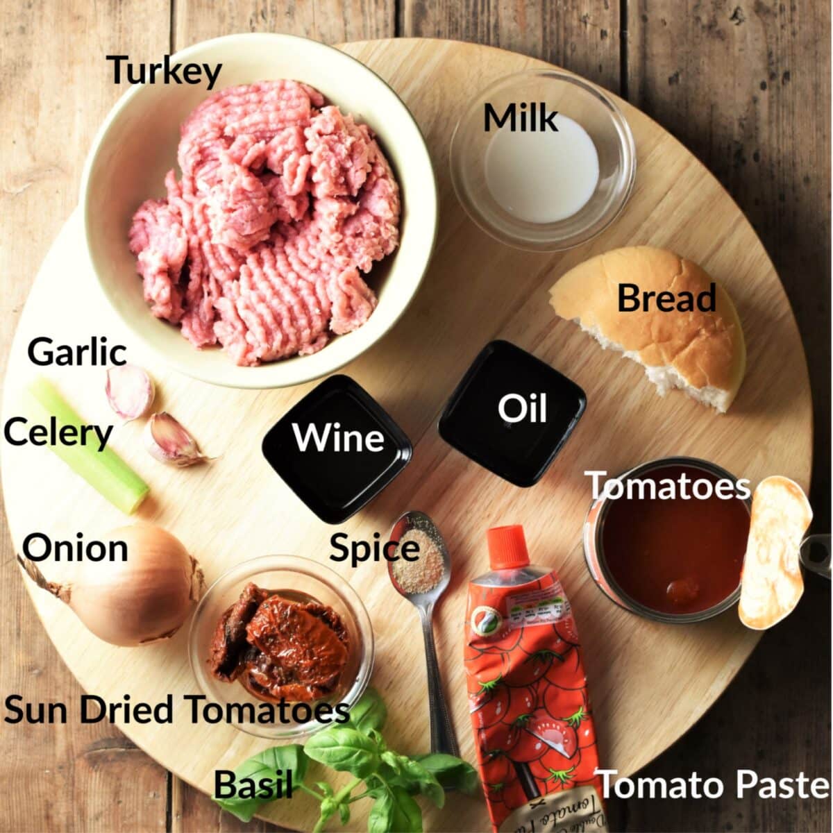 Meatballs in tomato sauce ingredients on top of round board.