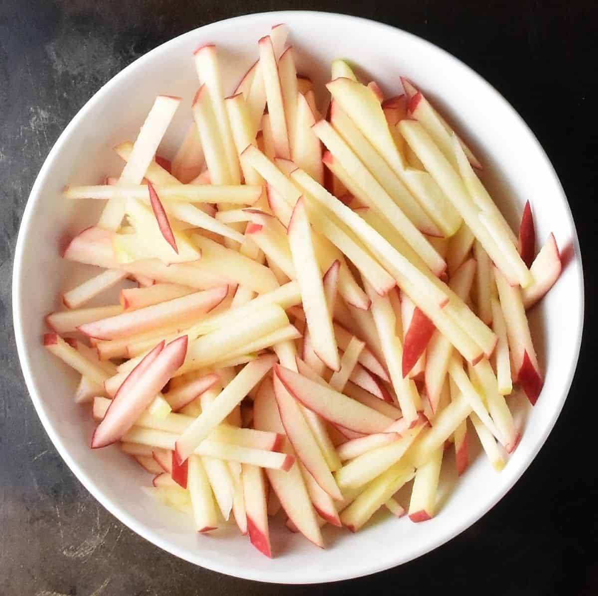 Apple matchsticks in white bowl.
