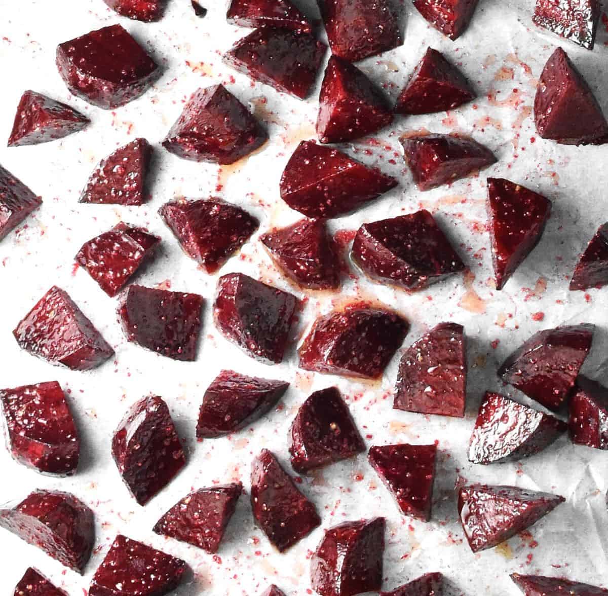 Beet chunks spread on parchment paper.