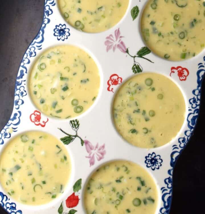 Quinoa egg muffin batter in 6-hole ceramic muffin pan.