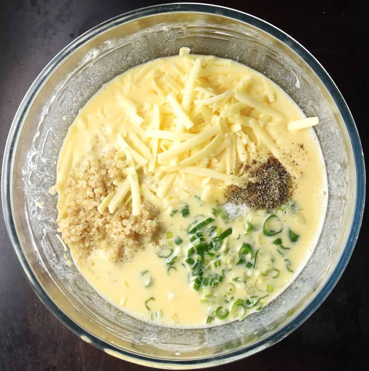 Top down view of quinoa and egg wet ingredients in bowl.