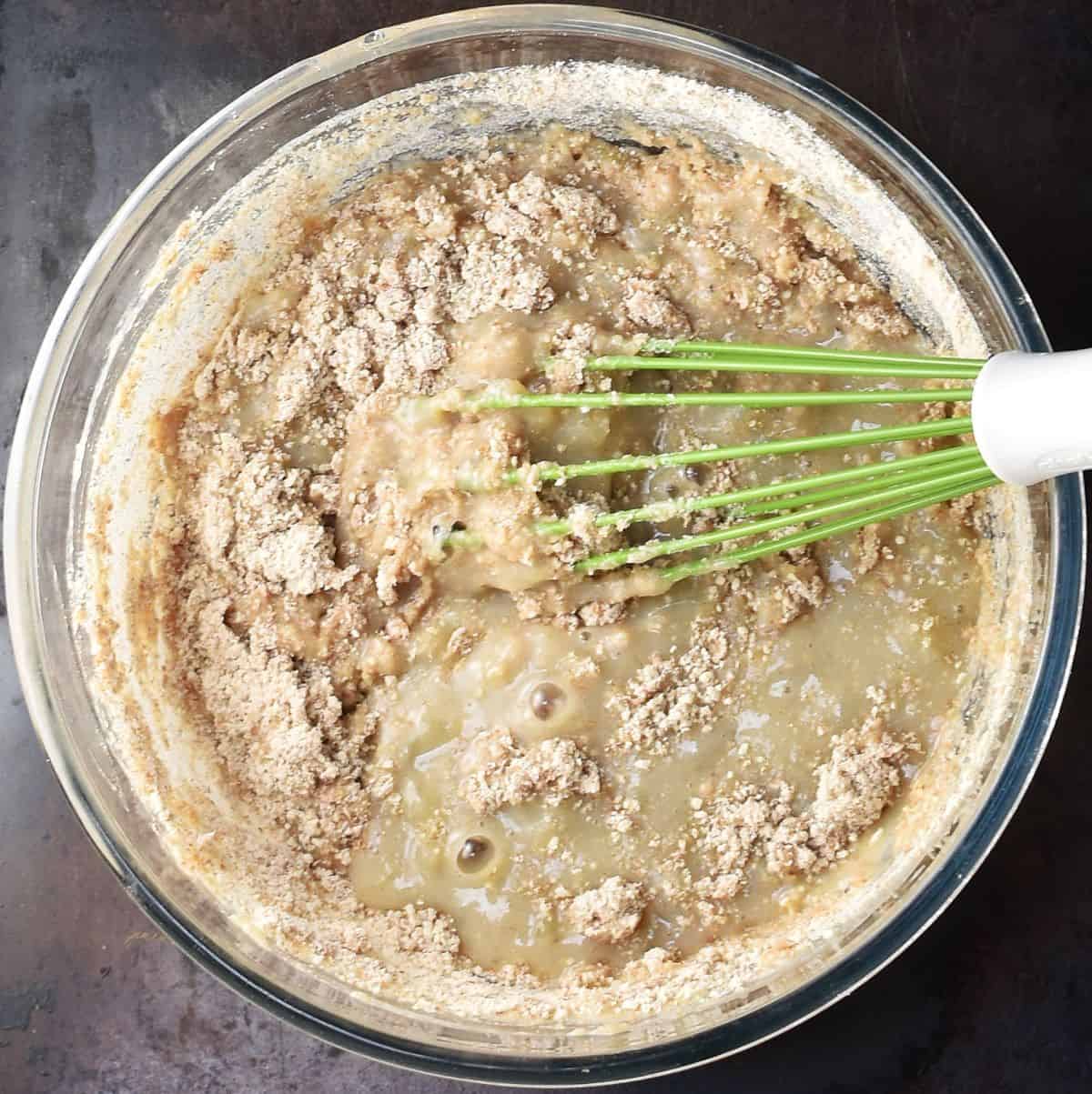 Combining wet with dry ingredients for banana and pear bread in bowl.