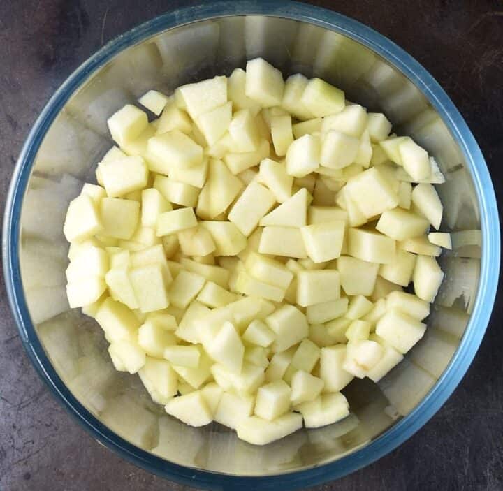 Top down view of peeled, diced pears in glass bowl.