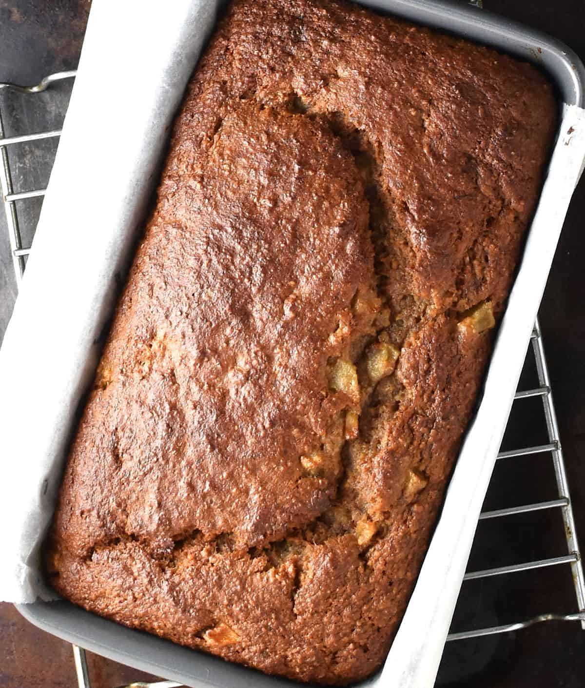 Top down view of baked banana pear bread in loaf pan with parchment.