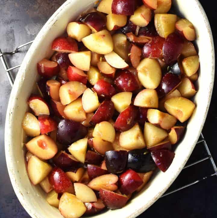 Plum filling for crumble in oval white dish.