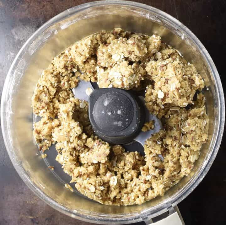 Vegan plum crumble topping mixture in food processor bowl.