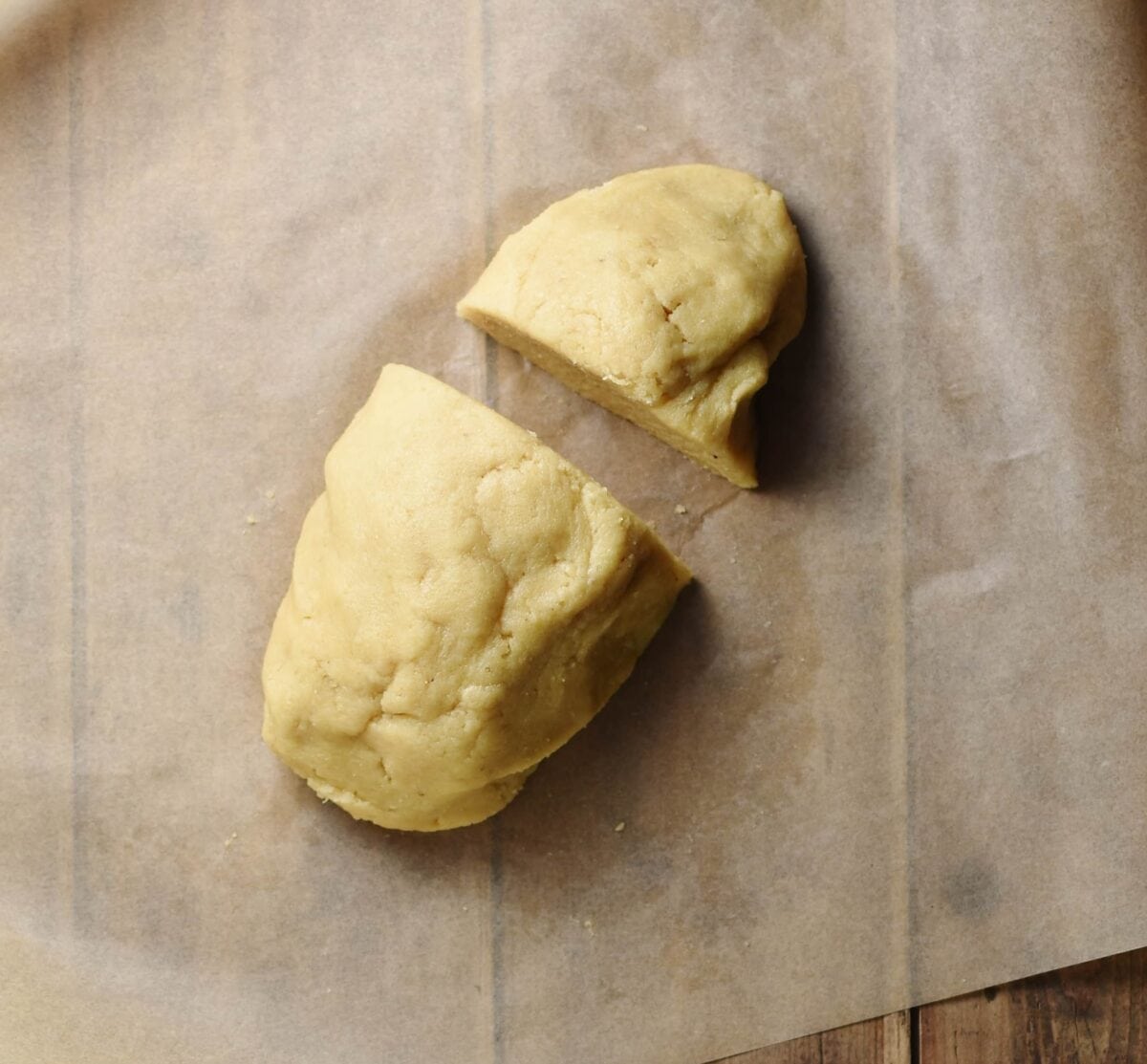Cake dough divided into 2 parts on top of parchment paper.