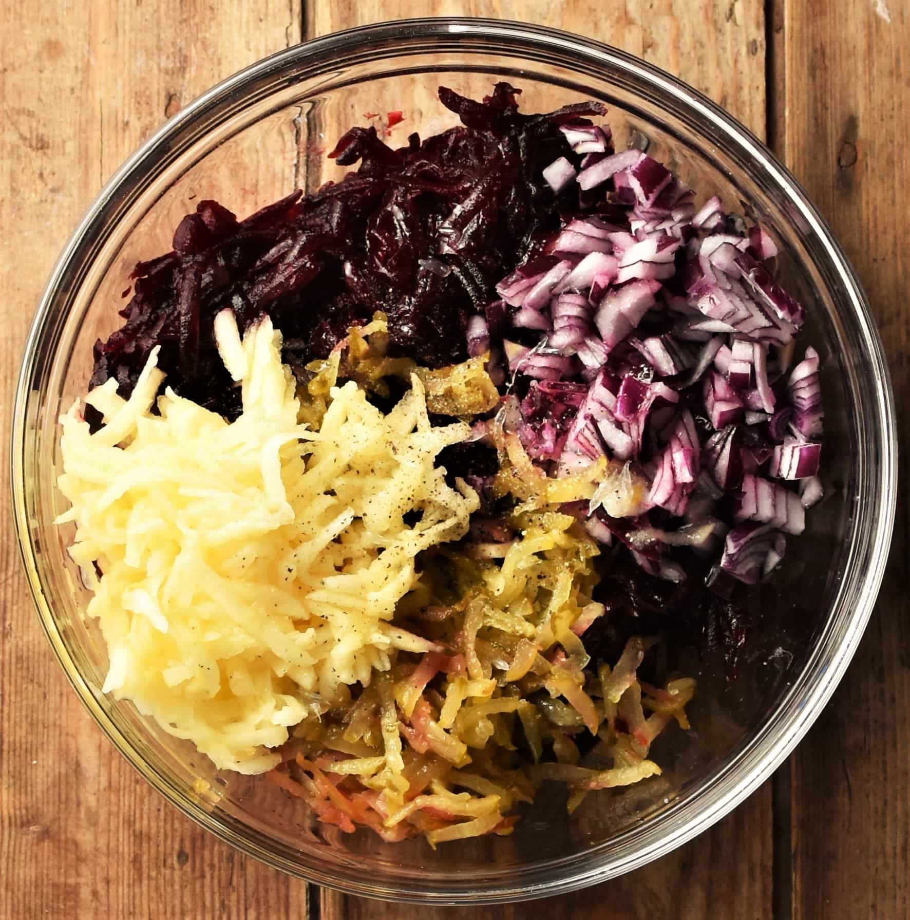 Grated beet, apple, dill pickle and chopped red onion in mixing bowl.