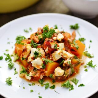 Tuna bake with butternut squash, spinach and feta on white plate.