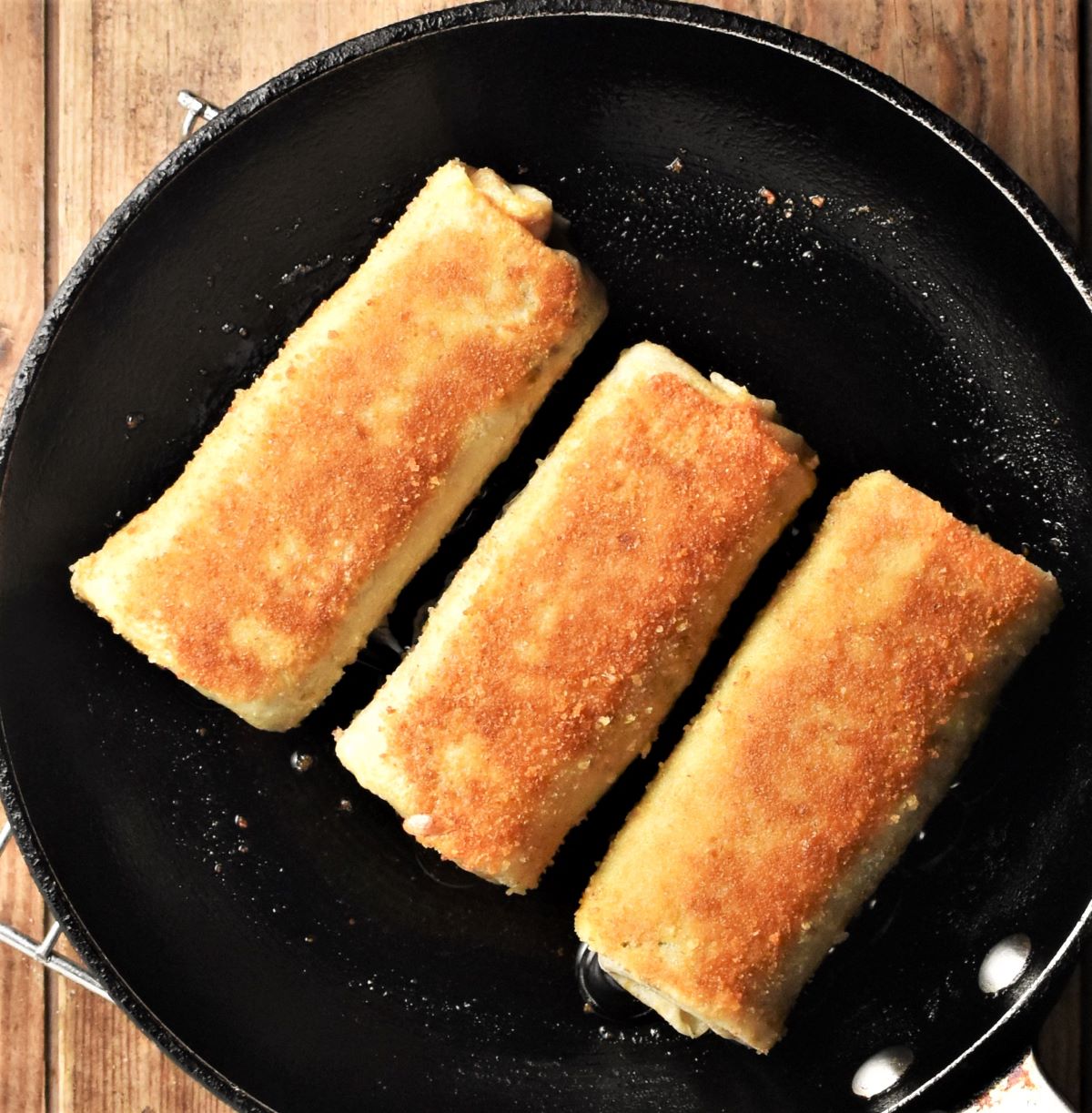 3 fried lightly browned krokiety on top of pan.
