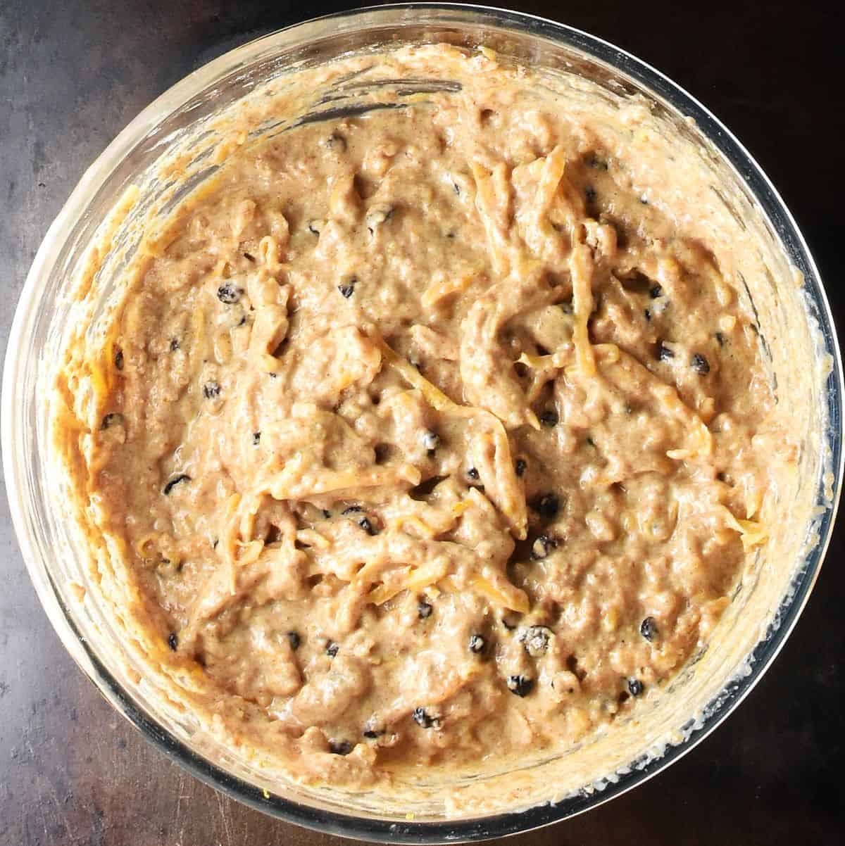 Thick butternut squash muffin batter in glass bowl.