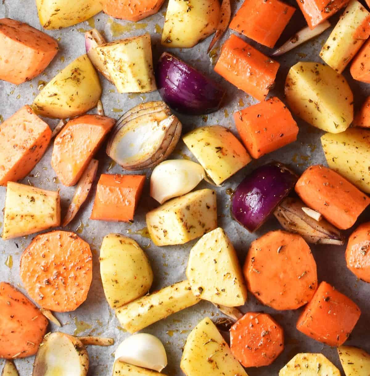 Pieces of raw root vegetables on top of parchment.