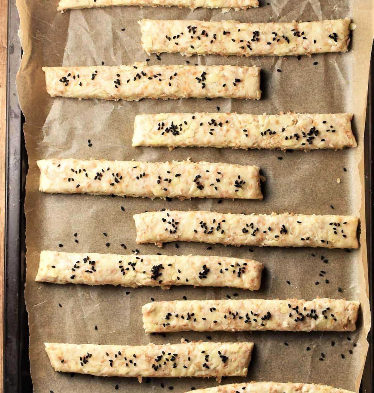 Breadsticks on top of baking sheet lined with parchment.