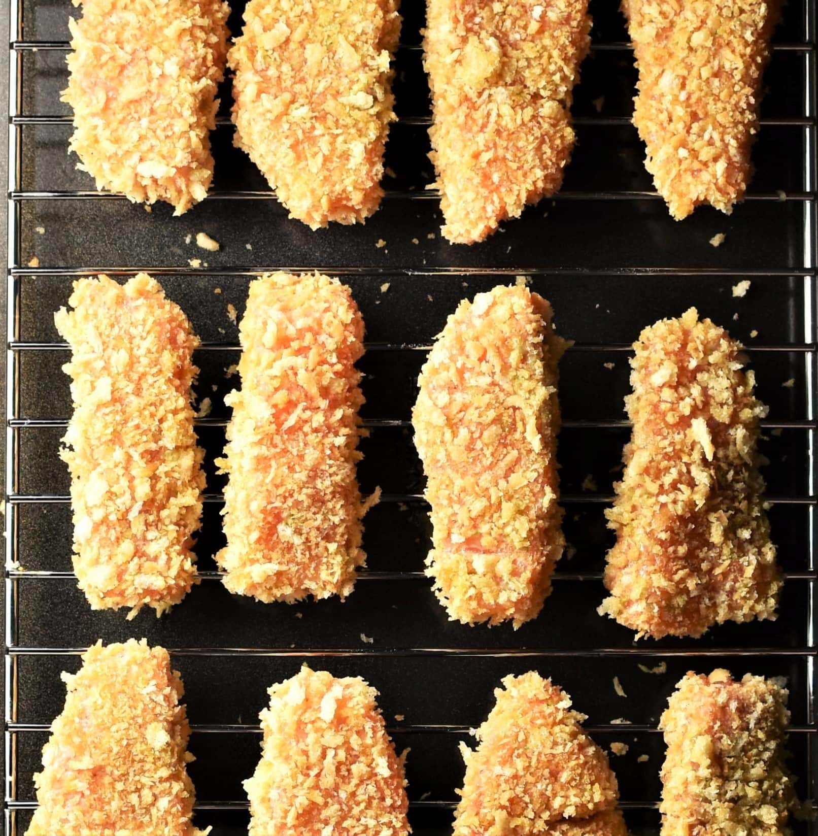Unbaked breaded salmon pieces on top of rack.