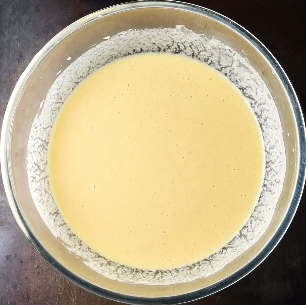 Creamy wet muffin mixture in glass bowl.