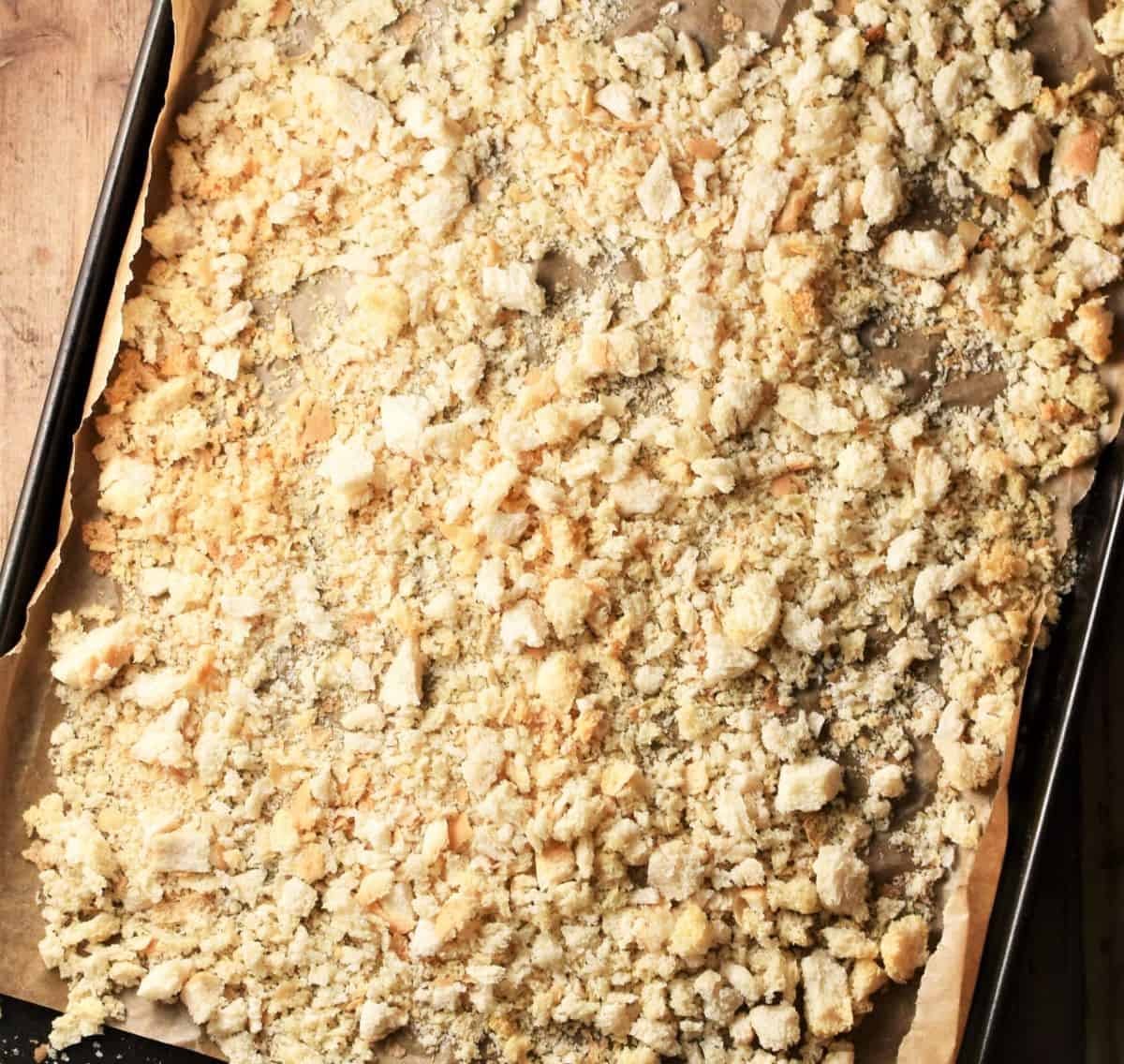 Toasting breadcrumbs on baking sheet lined with parchment.