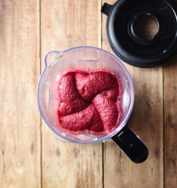 Top down view of beetroot hummus inside blender.