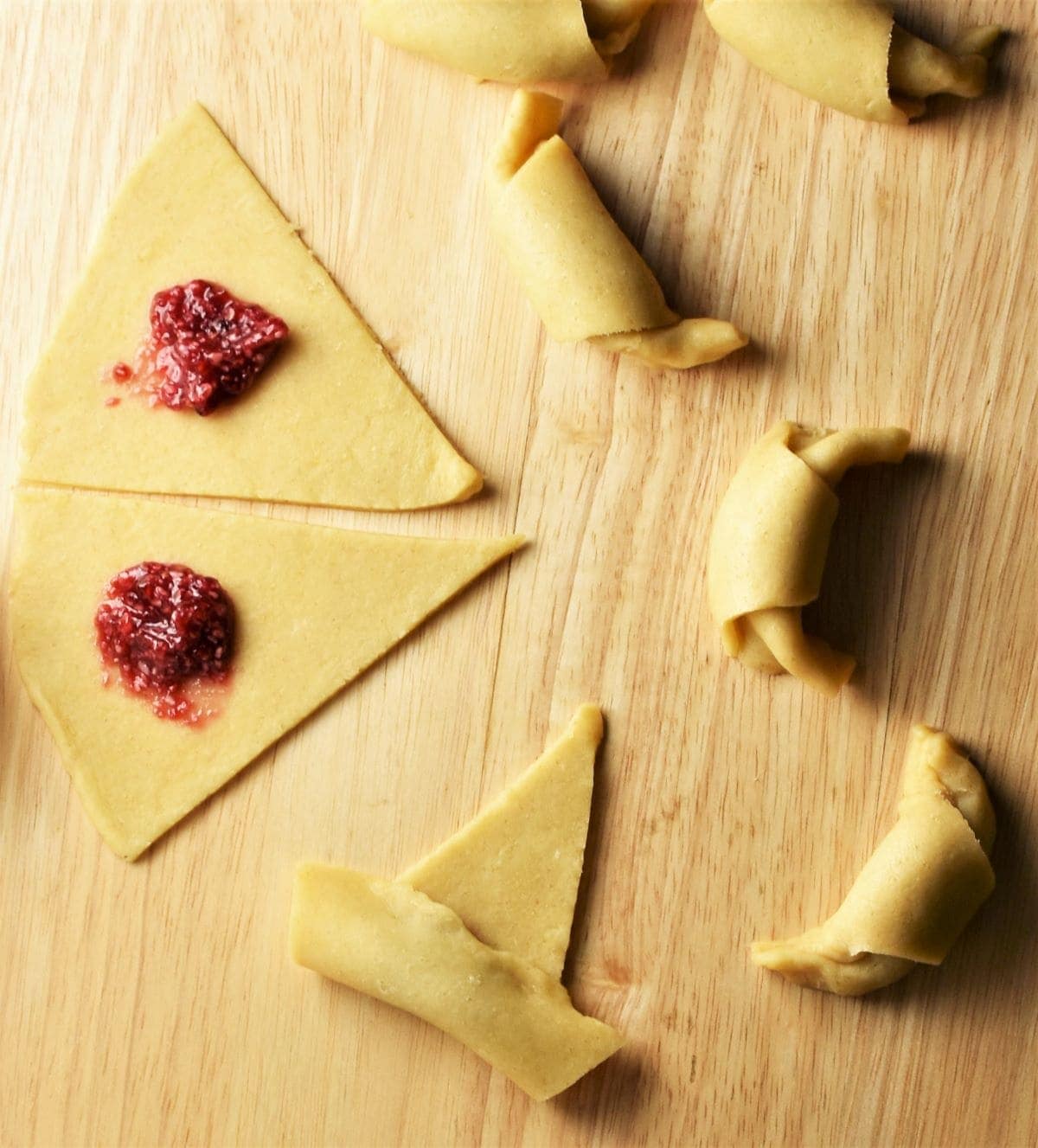 Rogaliki pastry with jam filling on top of wooden board.