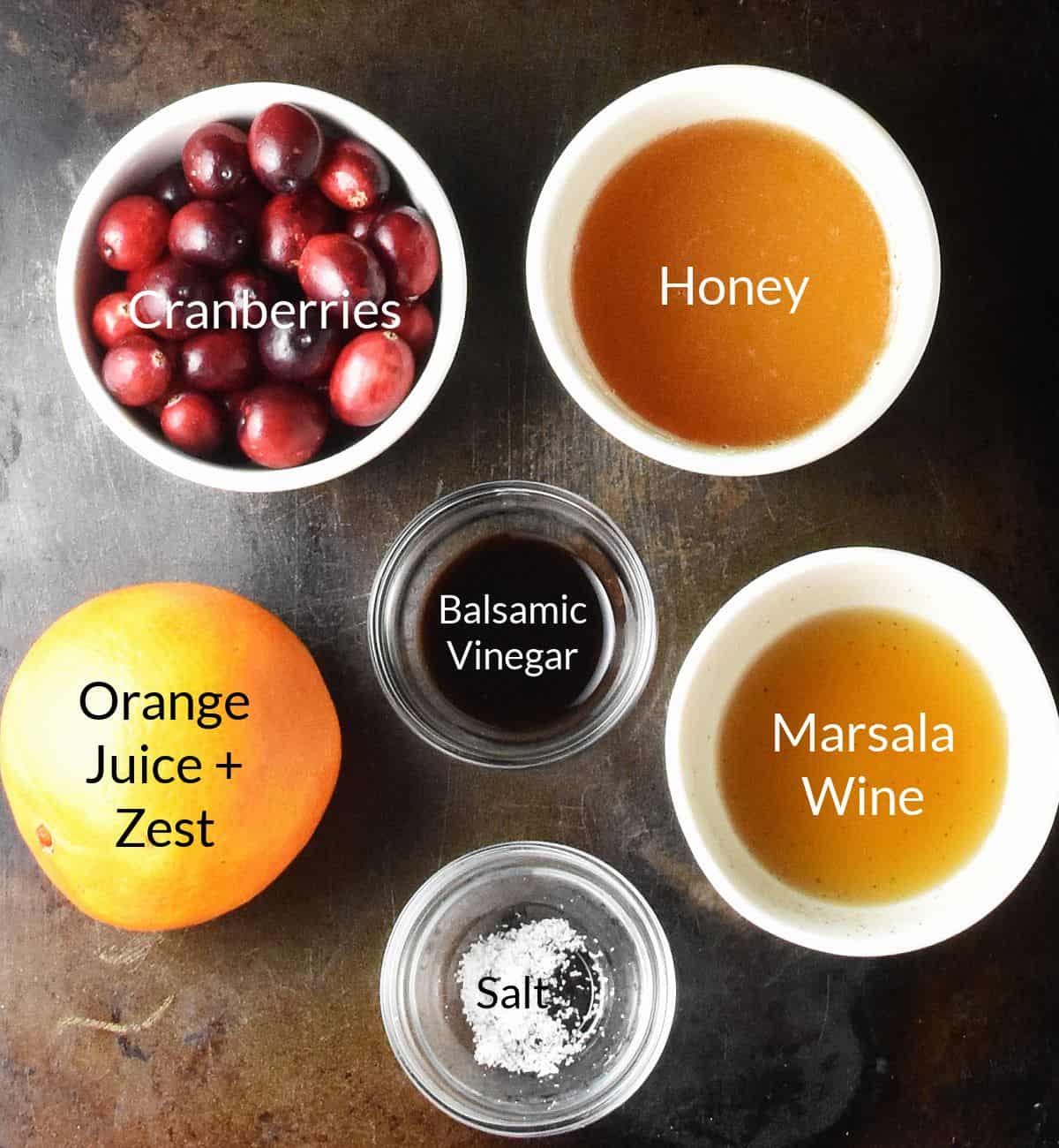 Ingredients for making cranberry honey sauce in individual dishes.