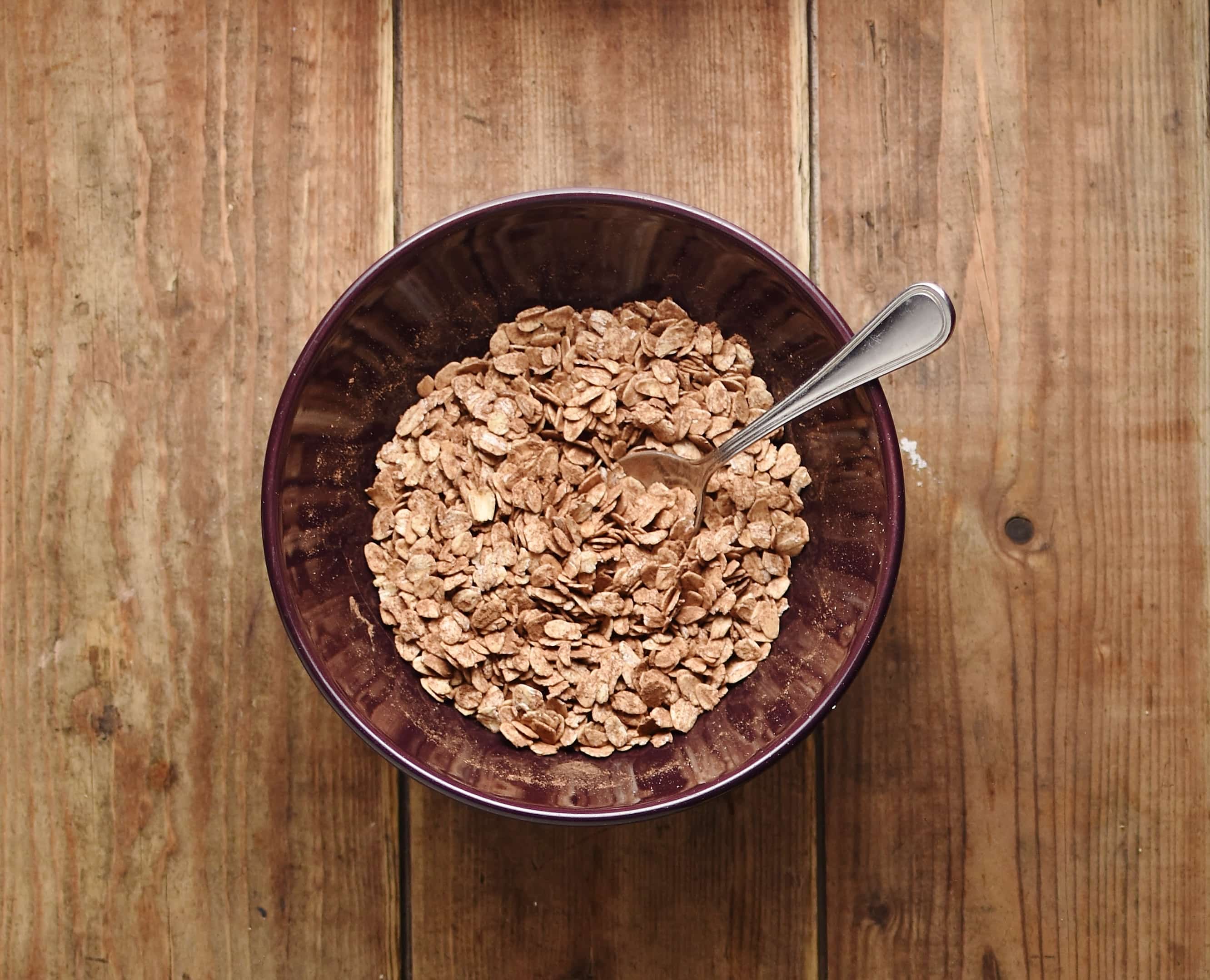 Oats with cocoa and soon in purple bowl.
