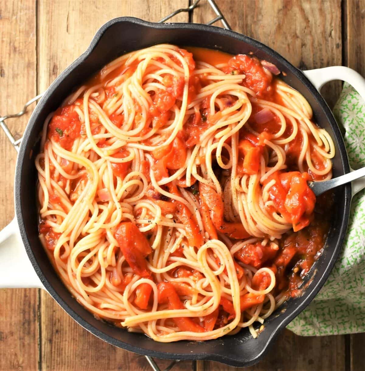 Spaghetti with chunky tomato and red pepper sauce in pan.
