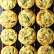 Top down view of 12 asparagus egg muffins on top of rack.