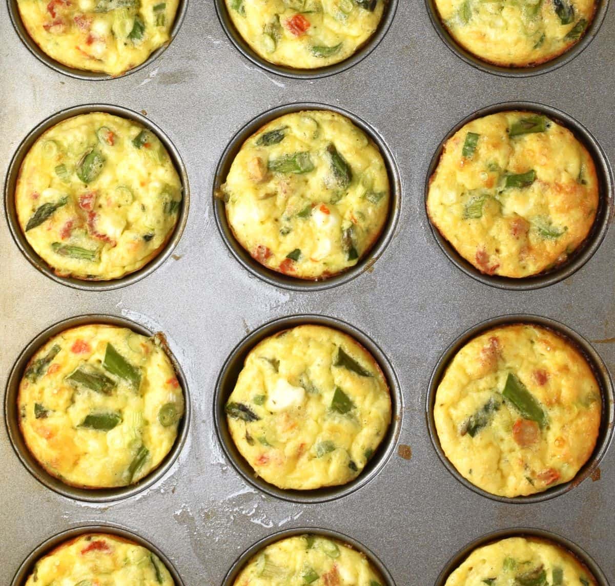 Top down view of baked asparagus muffins in pan.