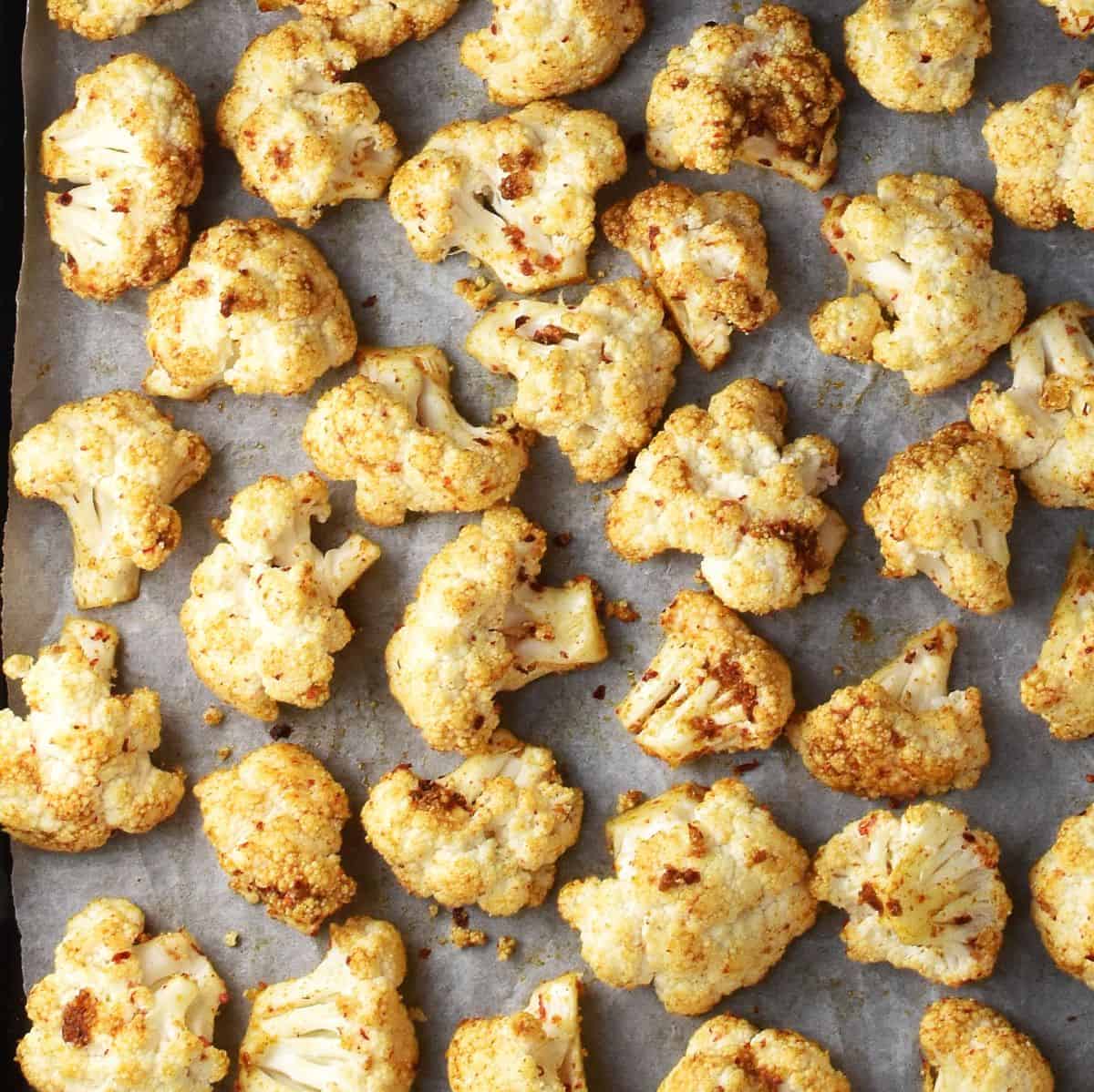 Spiced cauliflower florets on top of parchment.