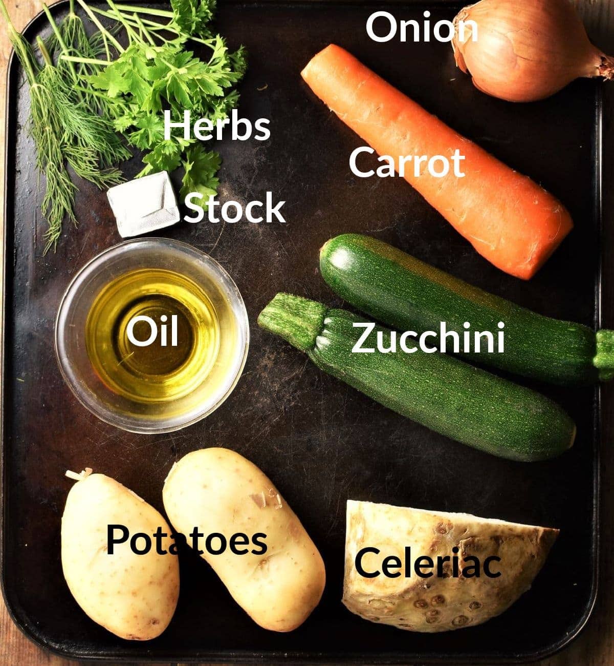 Vegetable noodle soup ingredients on top of black surface.