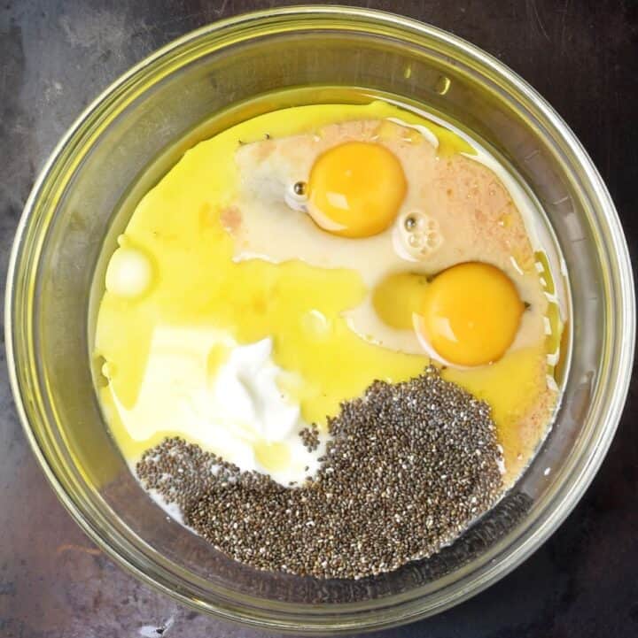 Chia seeds and wet pancake ingredients in glass bowl.