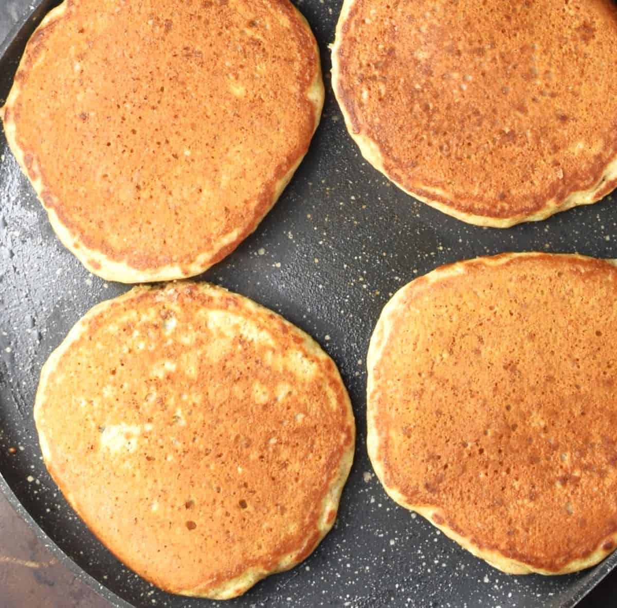 4 cooked pancakes with chia in large pan.