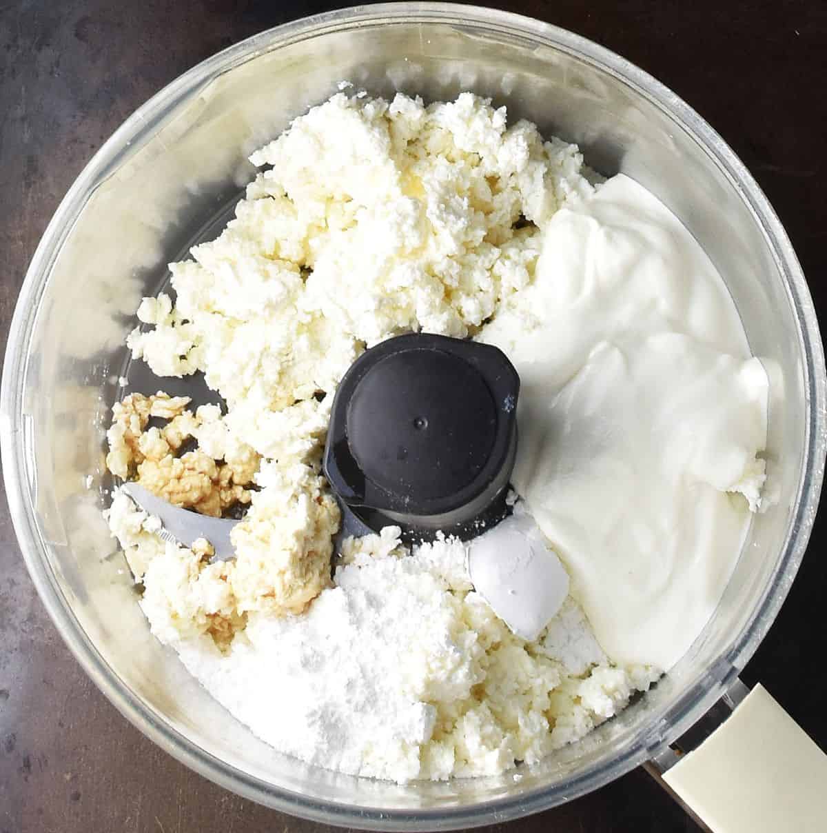 Twarog cheese, sour cream and powdered sugar in food processor bowl.