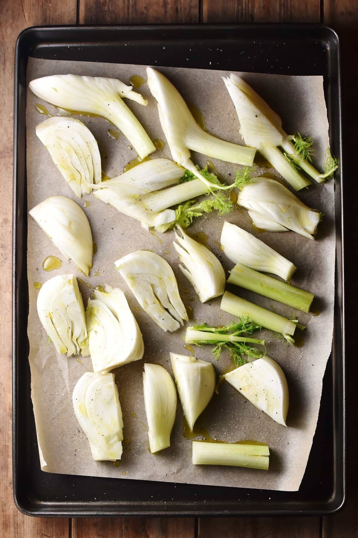 Fennel pieces on top of baking sheet lined with parchment paper.