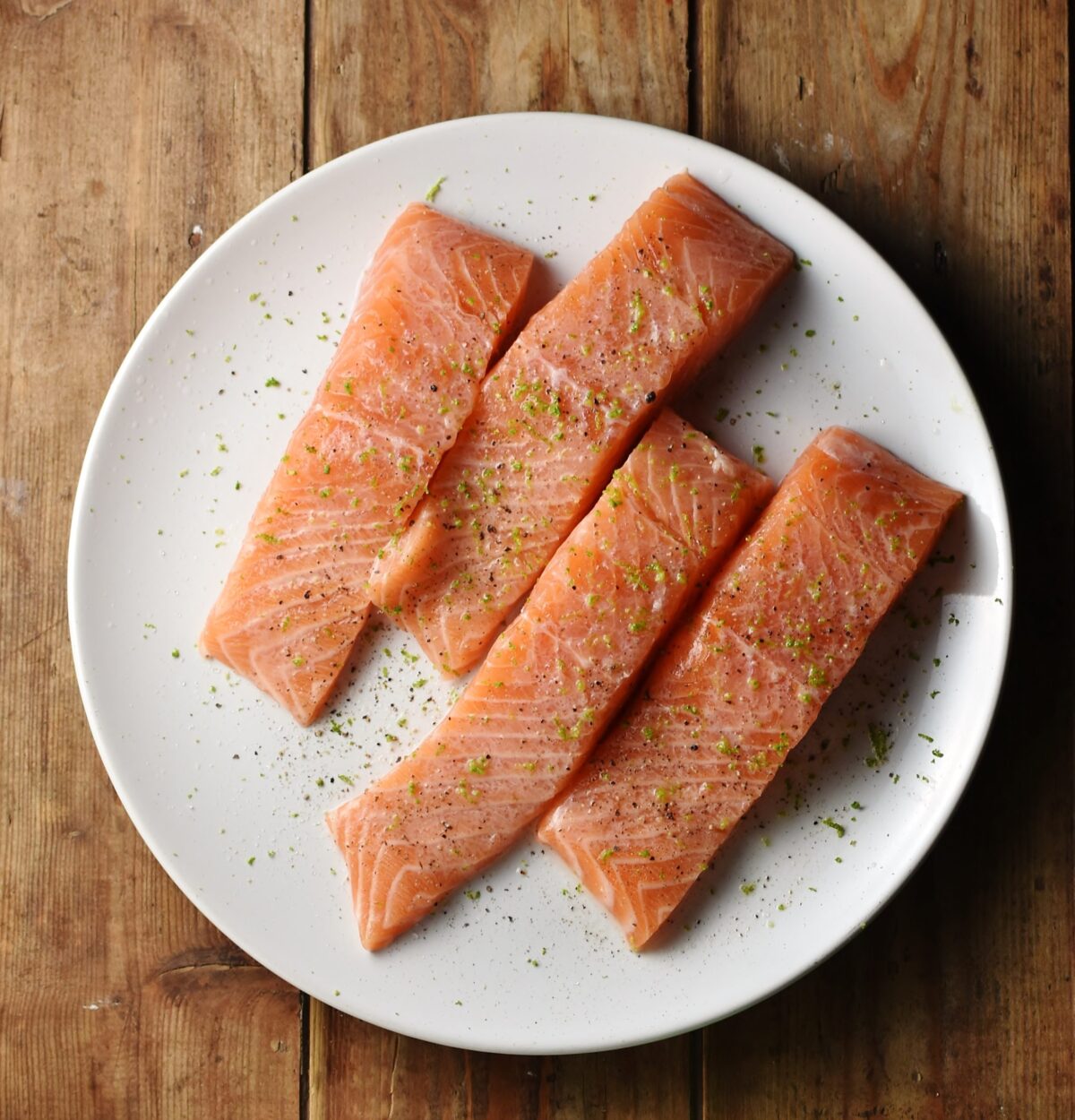 4 salmon pieces on top of white plate.